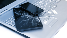 silver-laptop-with-broken-keyboard-tablet-with-cracked-display-and-black-phone-close-up