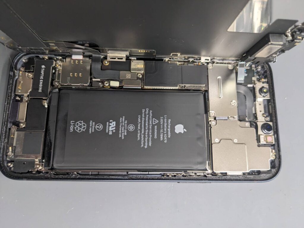 iPhone12の内部を開きバッテリー交換作業を行っている様子