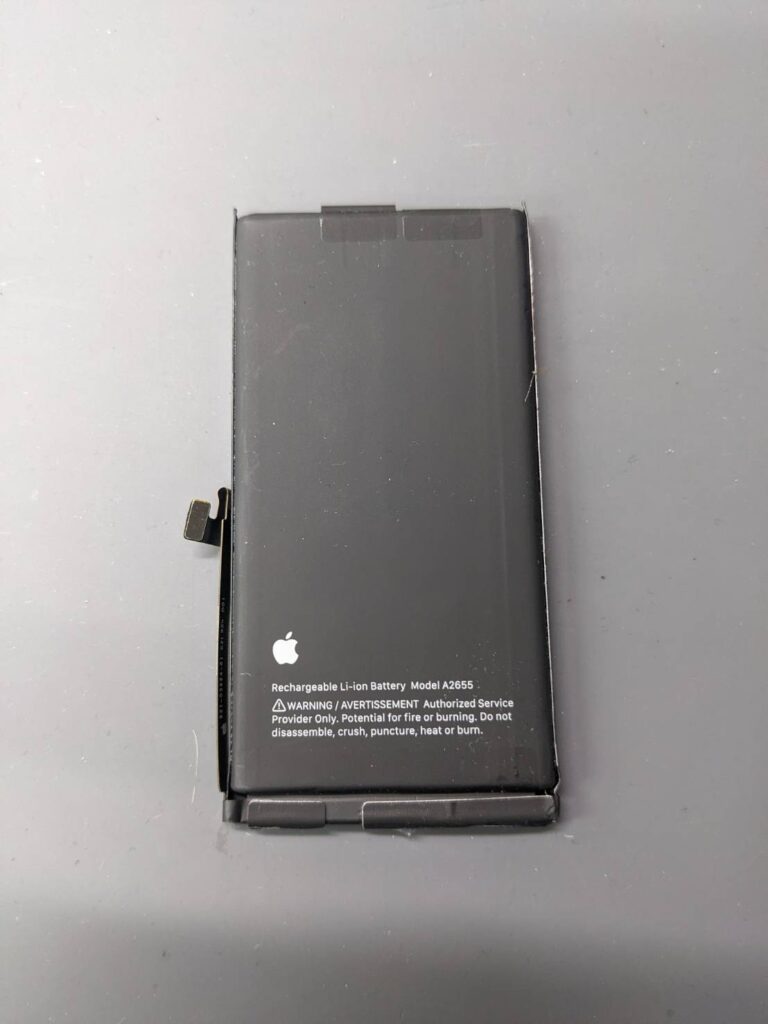 iPhone13から取り外した劣化した純正バッテリー。バッテリー交換修理時の取り外し部品の様子。