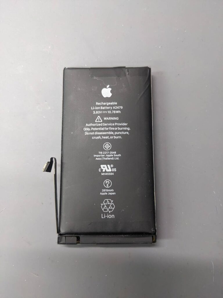 iPhone12から取り外した劣化した純正バッテリー。iPhone12のバッテリー交換修理で取り外した部品の状態。