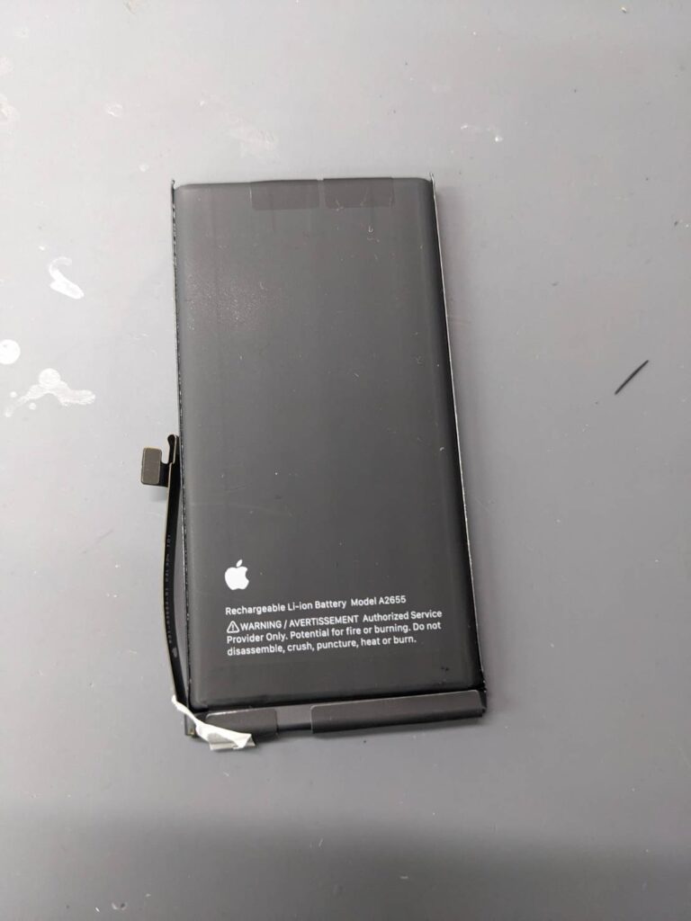 iPhone13から取り外した劣化したバッテリー部品の写真。バッテリー交換修理後の取り外し済み純正バッテリー。
