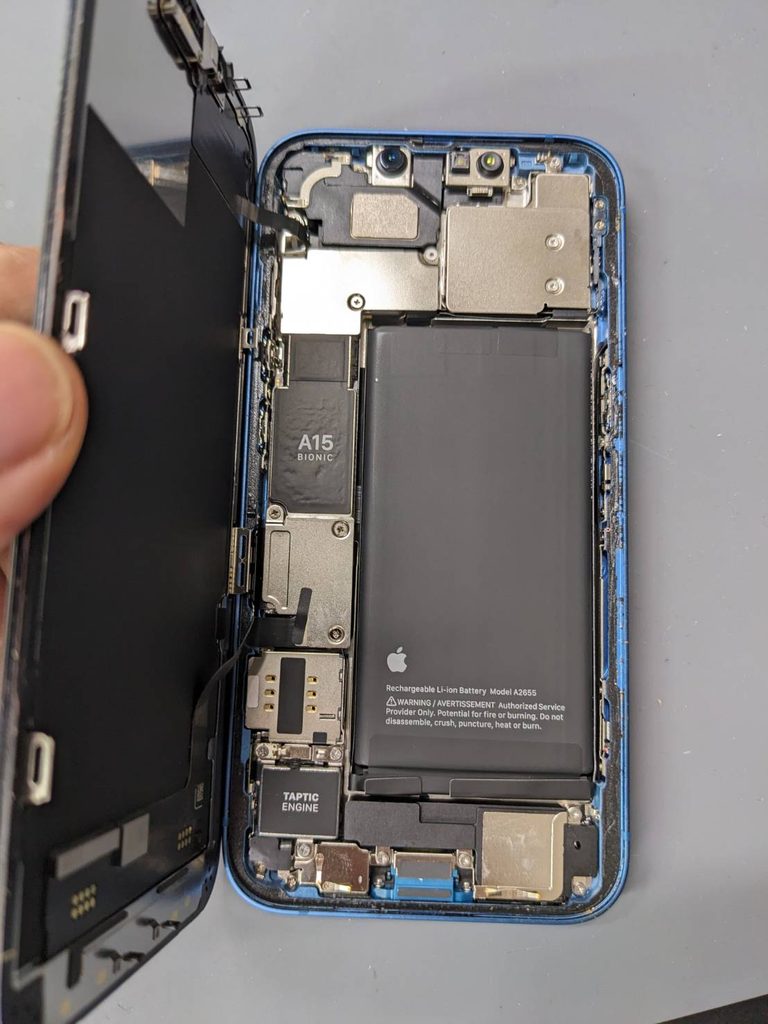 iPhone 13のバッテリー交換修理で本体を開き内部のバッテリーを確認している様子